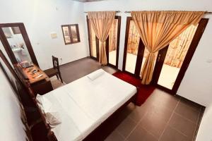 圣多美Refúgio Compacto的客房设有一张床、一张书桌和窗户。