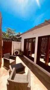 eine Terrasse mit Stühlen und Tischen auf einem Haus in der Unterkunft Refúgio Compacto in São Tomé + 1 Foto