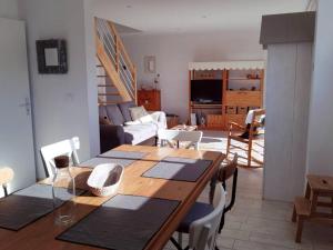 een eetkamer en een woonkamer met een tafel en stoelen bij Très beau gîte neuf et fonctionnel aux portes du Mans et du circuit in Teloché