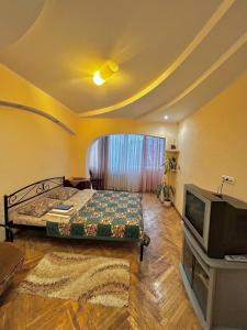 a bedroom with a bed and a tv in it at Apartment near train station and close to city center in Kyiv