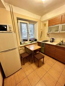 eine Küche mit einem Kühlschrank und einem Tisch darin in der Unterkunft Apartment near train station and close to city center in Kiew