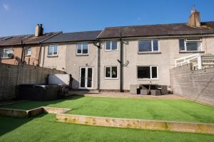 a yard with a lawn in front of a house at No40Barmouth-Modern,Spacious&Hot Tub in Barmouth