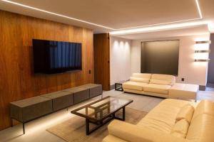 a living room with a couch and a flat screen tv at Alojamiento de lujo con la mejor vista de Polanco in Mexico City