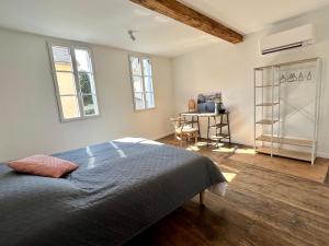 1 dormitorio con cama y escritorio en Le gîte du bonheur en Bagnères-de-Bigorre