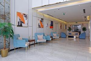 une salle d'attente avec des chaises et des tables bleues dans un bâtiment dans l'établissement وايت مون للاجنحة الفندقية الضيافة, à Khamis Mushait