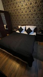 1 dormitorio con cama con sábanas y almohadas negras en Pension Chevermeto, en Chemnitz