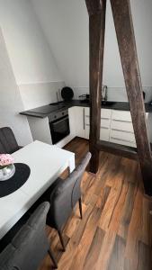Pension Chevermeto في شيمنيتز: مطبخ مع طاولة بيضاء وكراسي في غرفة