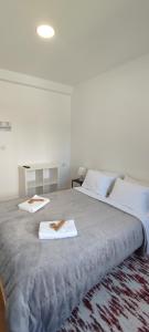 - un grand lit avec 2 serviettes dans l'établissement Habtiar Guest House, à Braga