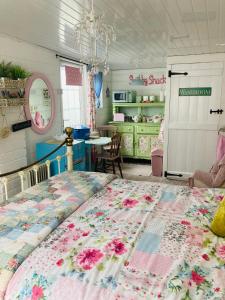 a bedroom with a large bed with a quilt on it at Shabby Shack near Charlestown & The Eden Project in St Austell