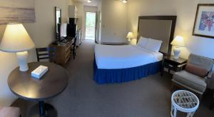 a hotel room with a bed and a couch and a table at Wessex Inn By The Sea in Cowichan Bay