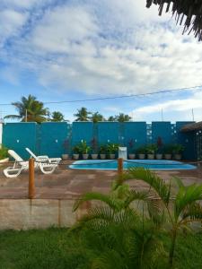 un complejo con piscina y pared azul en Wind Village Chalés en São Miguel do Gostoso