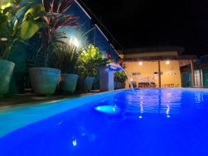 una piscina por la noche con luces azules en Wind Village Chalés en São Miguel do Gostoso