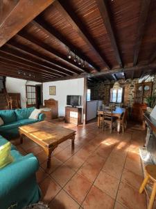 Casa Rural El Puente de Agues في Soto De Agues: غرفة معيشة مع أريكة وطاولة