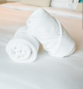 eine Rolle weiße Handtücher auf einem Bett in der Unterkunft Apto Cortegada in Vilagarcia de Arousa
