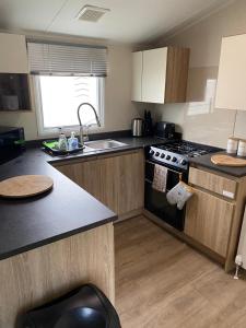 a kitchen with a sink and a stove top oven at Yogi's Space in Birchington
