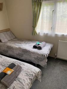 dwa łóżka w pokoju z oknem w obiekcie Yogi's Space w mieście Birchington
