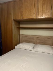 een slaapkamer met een bed met een houten hoofdeinde bij LONDON 1 BED COSY HOUSE in Norwood