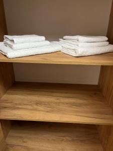 two towels are stacked on a wooden shelf at S-Nova in Gyumri