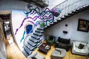 uma sala de estar com um mural na parede em Gente de Más Hostel em Puebla
