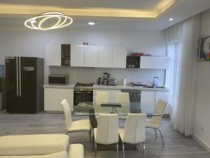 a kitchen with a table and chairs and a kitchen with white cabinets at White-House in Kigali