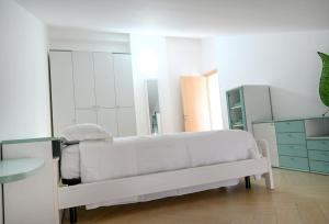 a white room with a bed and a mirror at Charlotte in Marconia