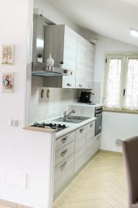 a white kitchen with a sink and a stove at Charlotte in Marconia