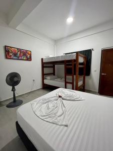 a bedroom with a bed and a bunk bed at Hostal Grand Park Palomino in Palomino