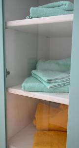 a closet with green towels on the shelves at Charlotte in Marconia
