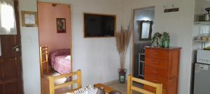 a living room with a television and a bedroom at Casas HG-Desayuno sencillo entregado al check in-Pileta climatizada en predio a 2 kilómetros-Acepta mascotas bajo petición-Cochera para 1 auto in Huerta Grande