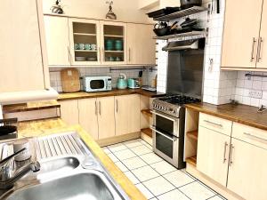een keuken met een wastafel en een fornuis top oven bij Aldgate Holiday Rooms in Londen