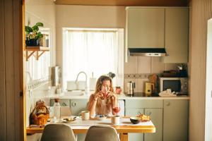 Casa Montse. Apartamentos turísticos في ريباديو: امرأة تجلس على طاولة في مطبخ