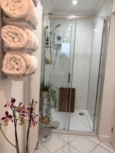 a bathroom with a shower with towels on a wall at Ocean Drive Boutique Apartment Brean Down complimentary Tray & continental Breakfast in Brean