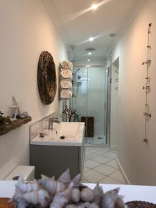 y baño con lavabo y ducha. en Ocean Drive Boutique Apartment complimentary Tray en Brean