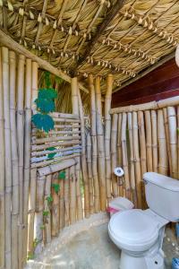 GuaiGüí Bayahibe في باياهيب: حمام مع مرحاض في جدار من الخيزران