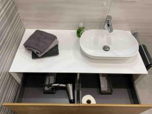 baño con lavabo blanco y toalla en Ferienwohnung Nalbach Wohnung 1, en Nalbach