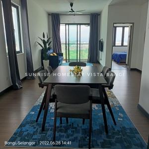 een eetkamer met een tafel en uitzicht op de oceaan bij Sunrise Homestay Vista Bangi in Kajang