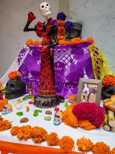 a table topped with flowers and a statue of a woman at Gente de Más Hostel in Puebla