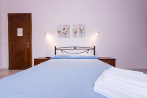- une chambre dotée d'un lit avec des draps bleus et des fleurs dans l'établissement Senka studios, à Parga