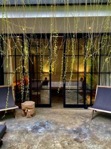 a room with glass doors and chairs and vines at The CIVYT in Ubud