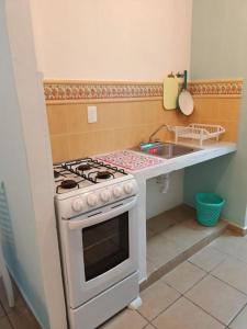 a kitchen with a stove and a sink at Hogar Dulce Hogar in Cancún