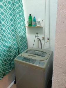 a washing machine in the corner of a bathroom at Hogar Dulce Hogar in Cancún