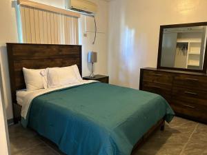 a bedroom with a bed and a dresser with a television at Beautiful Condos walking distance to a private beach! in Tamuning