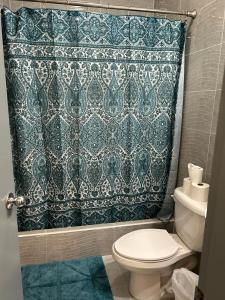 a bathroom with a toilet and a shower curtain at Beautiful Condos walking distance to a private beach! in Tamuning
