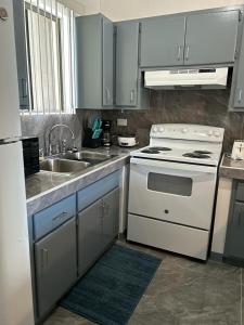 a kitchen with a white stove and a sink at Beautiful Condos walking distance to a private beach! in Tamuning