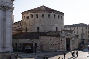 a large brick building with people standing around it at Piazza Duomo Cathedral View in Brescia