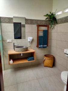 a bathroom with a sink and a mirror at Ilasan cottage. in Tomohon