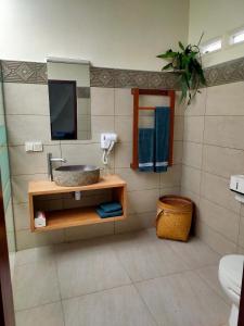 ein Badezimmer mit Waschbecken und Spiegel in der Unterkunft Ilasan cottage. in Tomohon