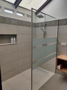 W łazience z przeszklonymi drzwiami znajduje się prysznic. w obiekcie Ilasan cottage. w mieście Tomohon