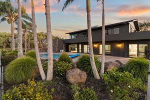 une maison avec une piscine et des palmiers dans l'établissement franklin chapel, à Clarks Beach