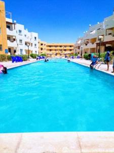una grande piscina con acqua blu di fronte agli edifici di Blue Lagoon Village Ras Sidr (قرية بلولاجون راس سدر) (عائلات فقط) a Ras Sedr